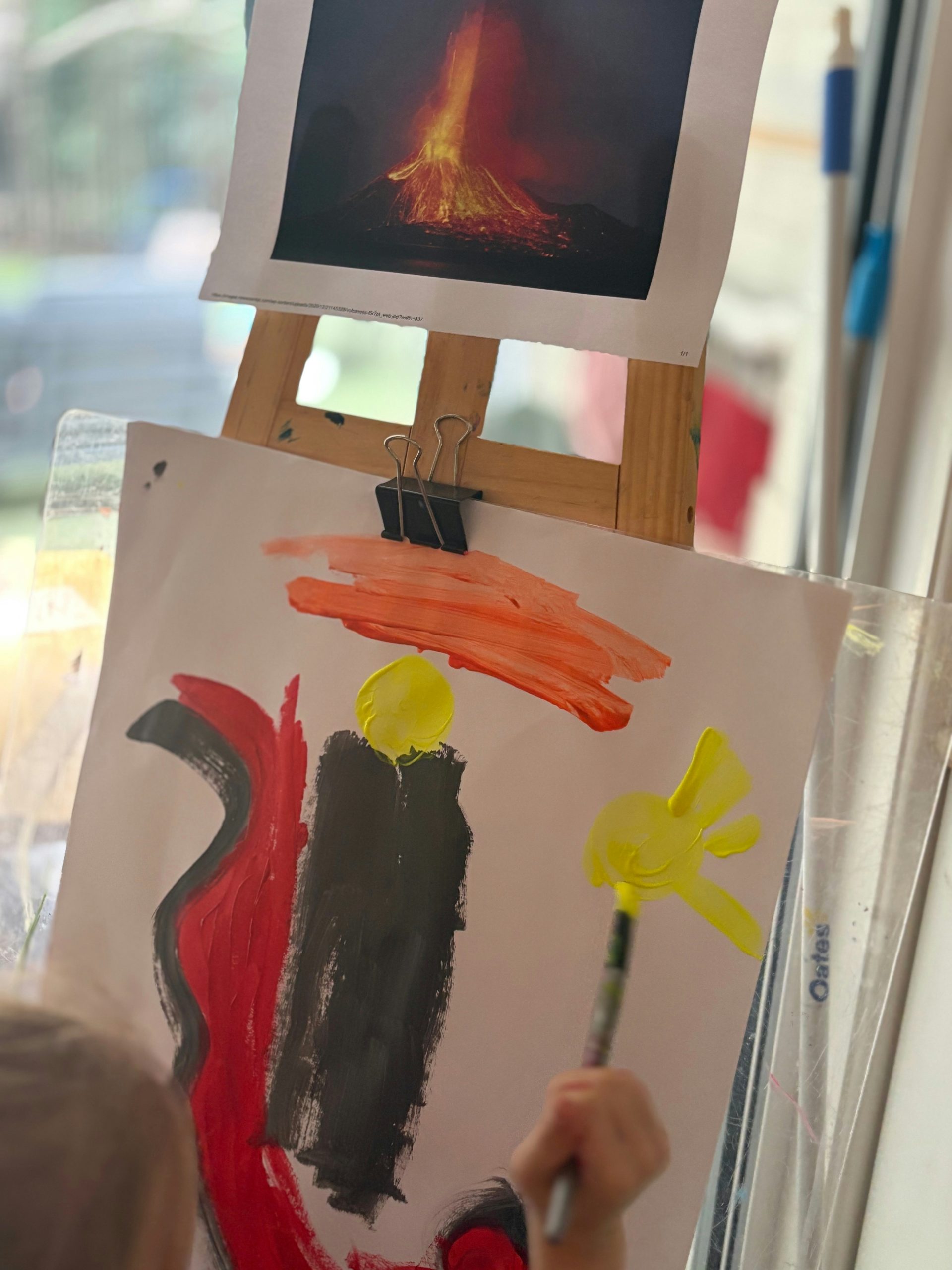 A child paints a volcano-inspired artwork.